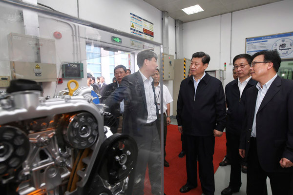 习近平在上海汽车集团技术中心动力总成试验室了解开发新能源动力汽车情况。