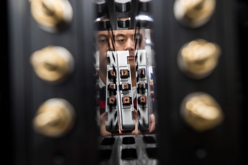 An employee installs a Lithium-ion battery cell into a testing system