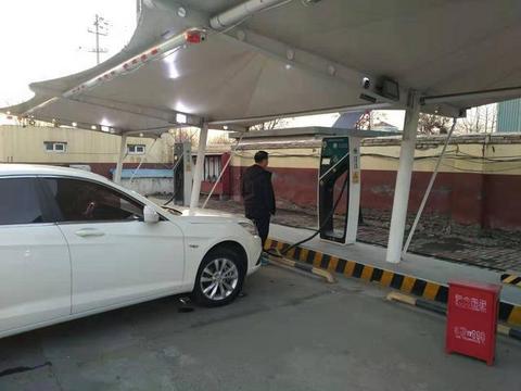 3月11日下午，在青银高速潍坊服务区，一位市民用充电桩给新能源汽车充电。