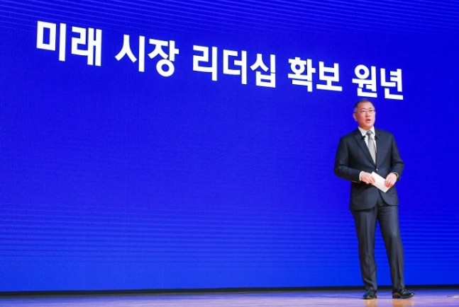 现代汽车集团首席副会长郑义宣，后边牌匾写着“确保未来市场领导力的元年”。