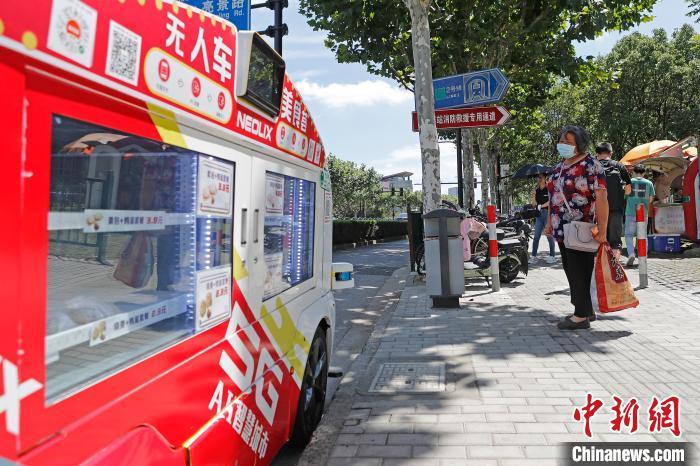無人餐車?？吭诘罔F出入口，吸引了市民的目光?！∫罅⑶?攝